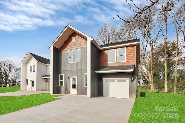 view of front of property featuring a front yard, an attached garage, and driveway