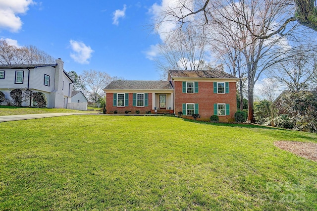 tri-level home with a front lawn and brick siding