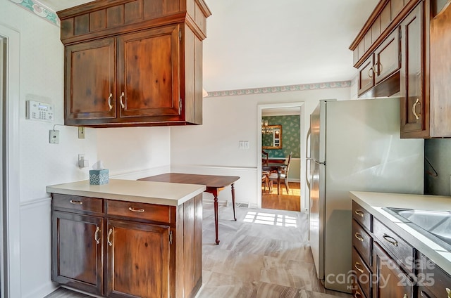 kitchen with light countertops, freestanding refrigerator, and a sink