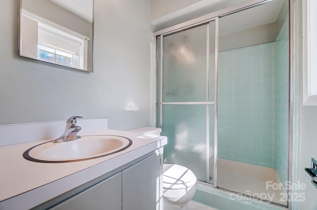 full bath with vanity, toilet, and a shower stall