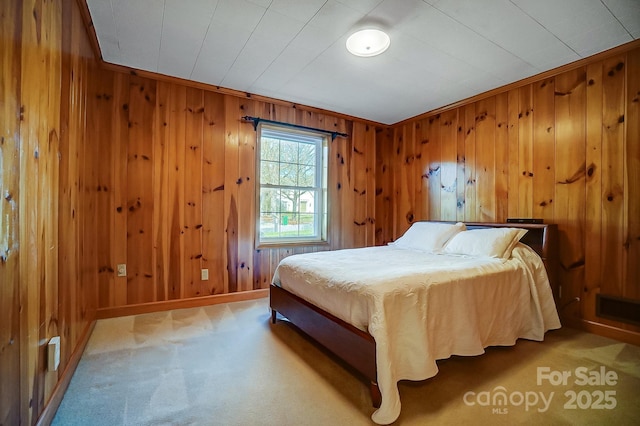 carpeted bedroom featuring baseboards and wooden walls