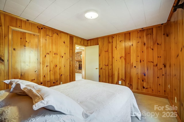 carpeted bedroom with wooden walls