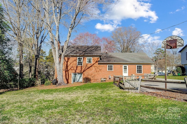 back of property with a yard and brick siding