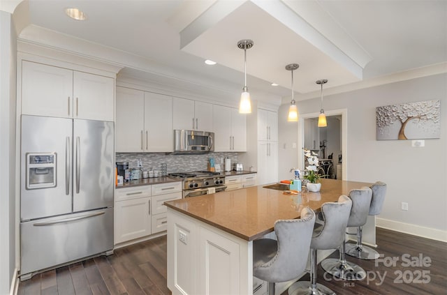 kitchen with appliances with stainless steel finishes, backsplash, an island with sink, and dark wood-style floors