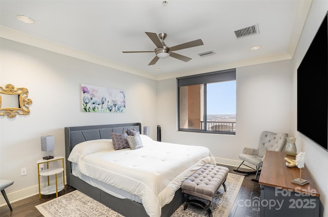 bedroom featuring ornamental molding, dark wood-style flooring, visible vents, and baseboards