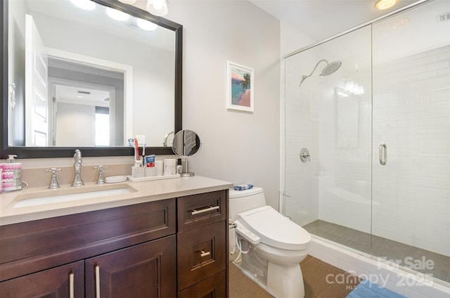 full bathroom featuring a stall shower, vanity, and toilet