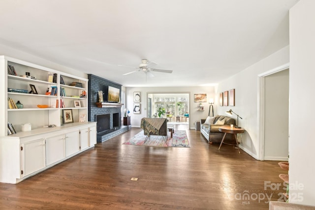 living room with ceiling fan, a fireplace, baseboards, and dark wood-style flooring