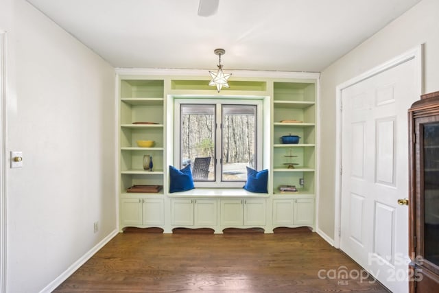 mudroom featuring dark wood-type flooring, built in features, and baseboards