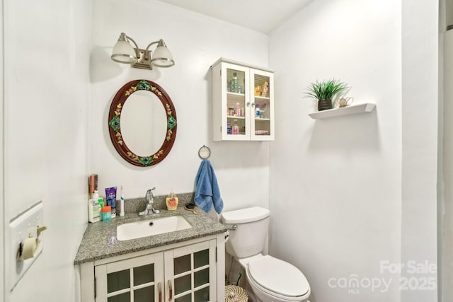 half bathroom with vanity and toilet