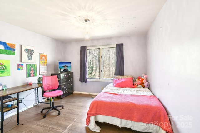 bedroom with baseboards and wood finished floors