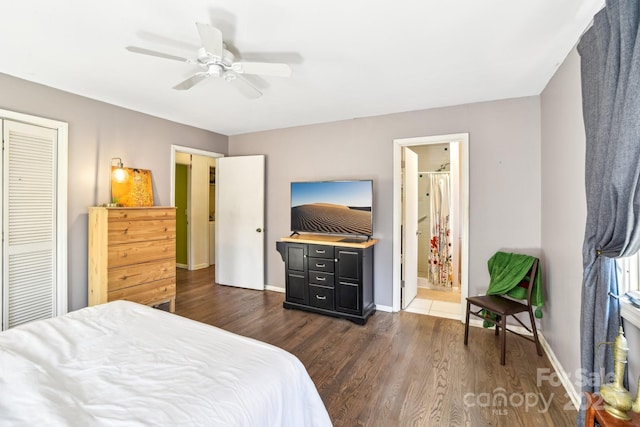 bedroom with dark wood-type flooring, ensuite bath, a ceiling fan, and baseboards