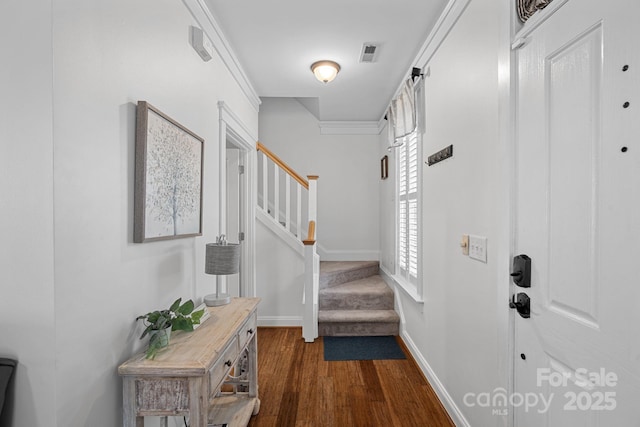 foyer entrance with dark wood-type flooring, stairway, visible vents, and baseboards