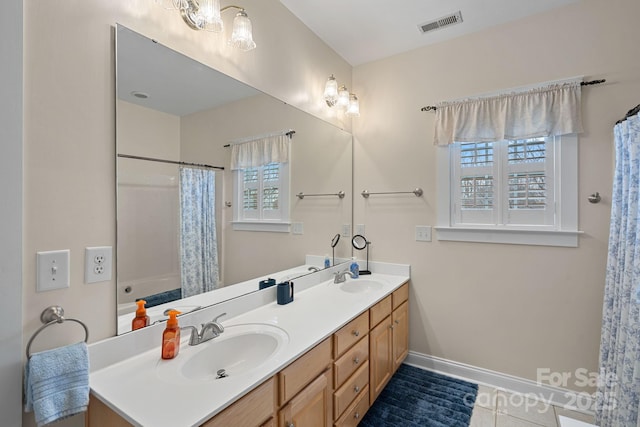 bathroom with double vanity, a sink, and a wealth of natural light