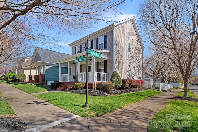 view of front of home featuring a porch, a front yard, and fence