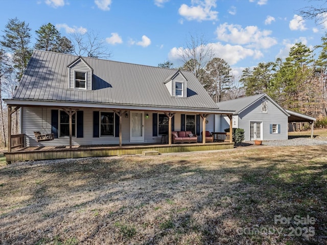 farmhouse inspired home featuring covered porch, metal roof, and a front yard