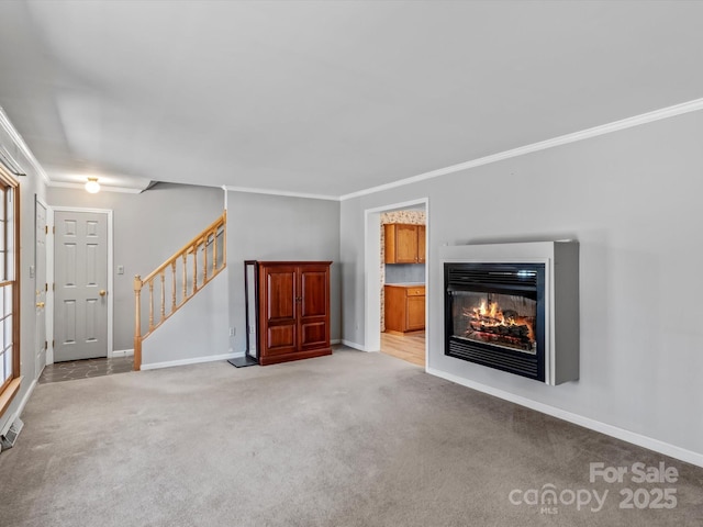 unfurnished living room with stairs, light carpet, a glass covered fireplace, and crown molding