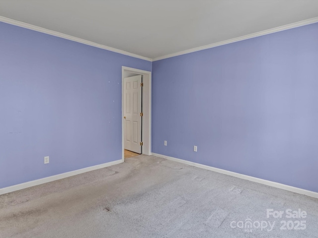 empty room with carpet floors, baseboards, and ornamental molding