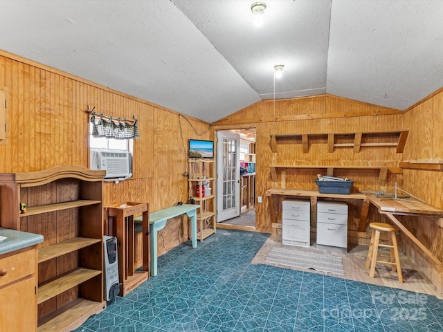 interior space with cooling unit, vaulted ceiling, wooden walls, and a textured ceiling