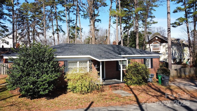 view of front of home with brick siding and a chimney