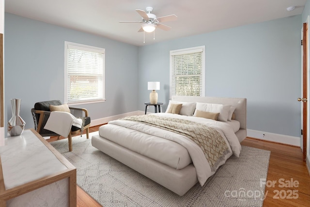 bedroom with baseboards, light wood-type flooring, and ceiling fan