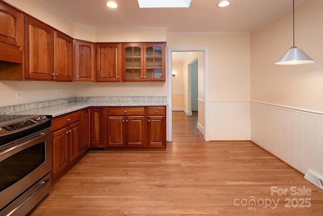 kitchen featuring light wood finished floors, visible vents, stainless steel electric range, and ornamental molding