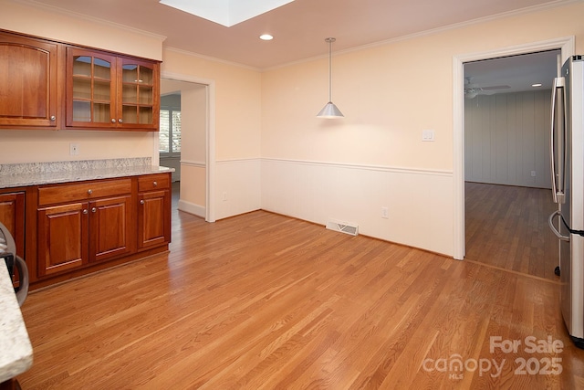 unfurnished dining area featuring visible vents, crown molding, recessed lighting, light wood-style flooring, and a skylight