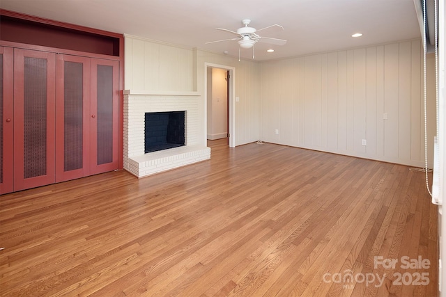 unfurnished living room with recessed lighting, a fireplace, light wood-type flooring, and ceiling fan