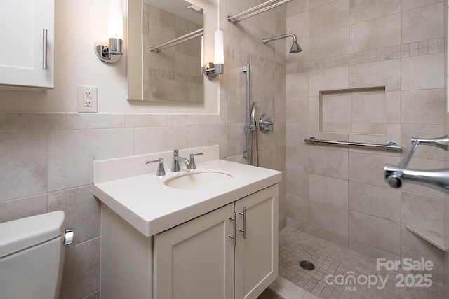 full bath with vanity, tile walls, toilet, and tiled shower