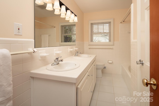 bathroom with tile patterned flooring, double vanity, shower / bathtub combination, and a sink