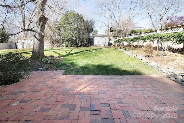 view of yard featuring an outbuilding, a shed, a patio, and fence