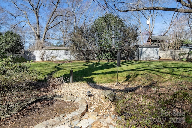 view of yard featuring a fenced backyard, an outdoor structure, and a shed