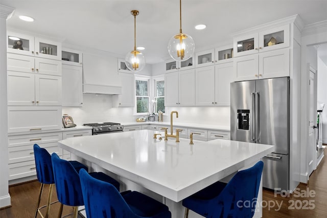 kitchen featuring dark wood-style flooring, light countertops, appliances with stainless steel finishes, backsplash, and custom exhaust hood