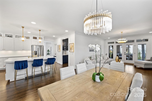 dining area featuring french doors, dark wood-type flooring, recessed lighting, and a notable chandelier