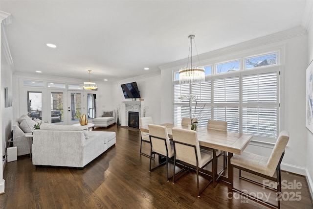 dining space featuring a fireplace with flush hearth, dark wood finished floors, and a notable chandelier