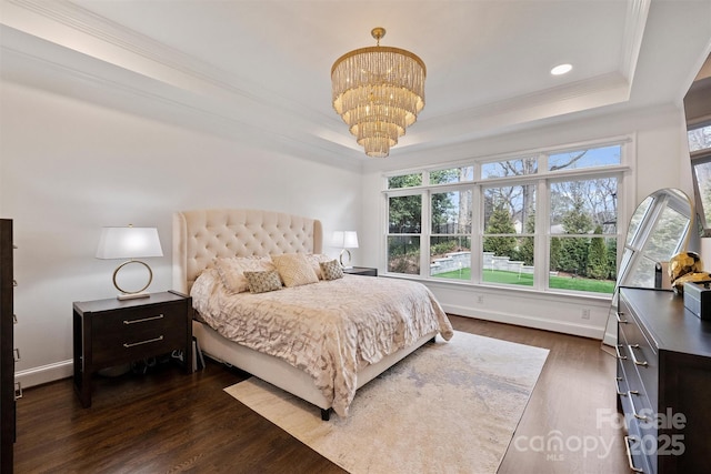 bedroom featuring dark wood-style floors, a notable chandelier, a raised ceiling, and crown molding