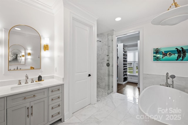 bathroom featuring a stall shower, marble finish floor, a freestanding tub, and crown molding