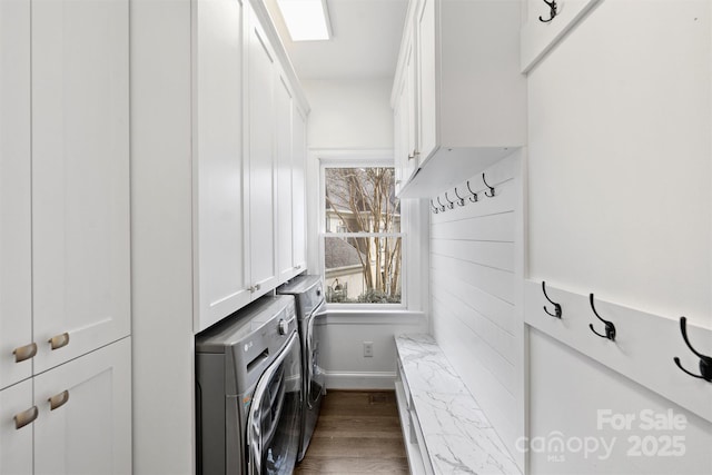 laundry area with wood finished floors, washing machine and dryer, cabinet space, and baseboards