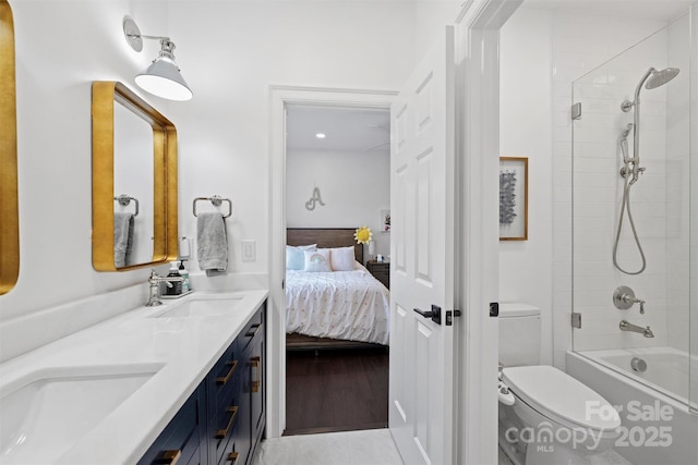 ensuite bathroom featuring ensuite bathroom, double vanity, a sink, and toilet