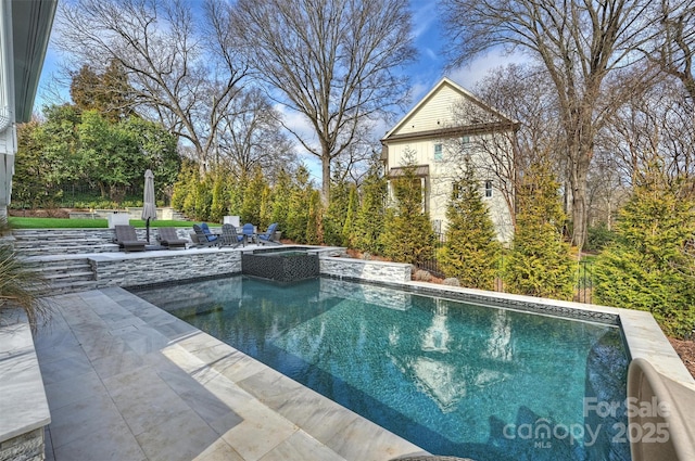 outdoor pool featuring an in ground hot tub and a patio