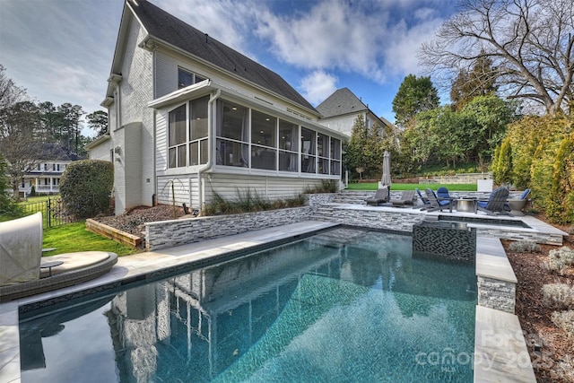 pool with a sunroom, a patio area, fence, and a fire pit