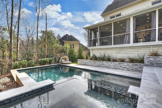 outdoor pool with a patio area and a sunroom