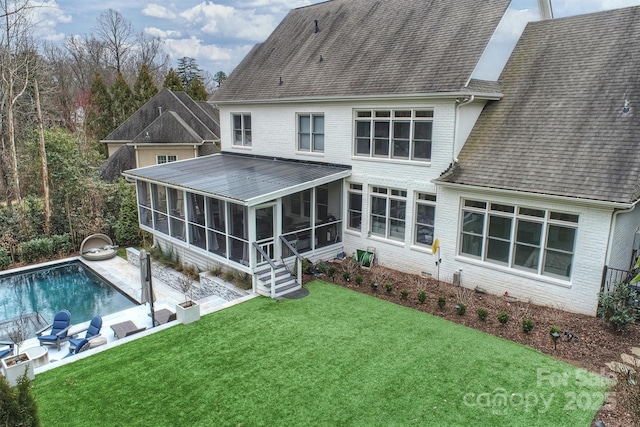 back of house featuring brick siding, a shingled roof, a sunroom, a yard, and an outdoor pool