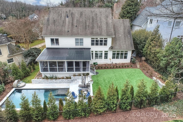 back of house with a sunroom, a fenced backyard, a shingled roof, and a lawn