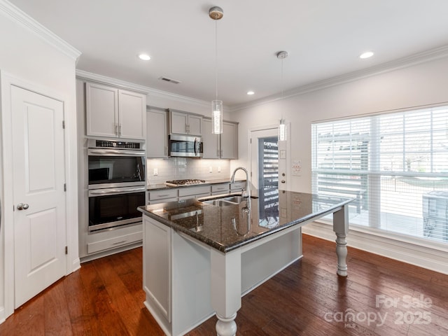 kitchen with dark wood finished floors, crown molding, stainless steel appliances, gray cabinets, and a sink