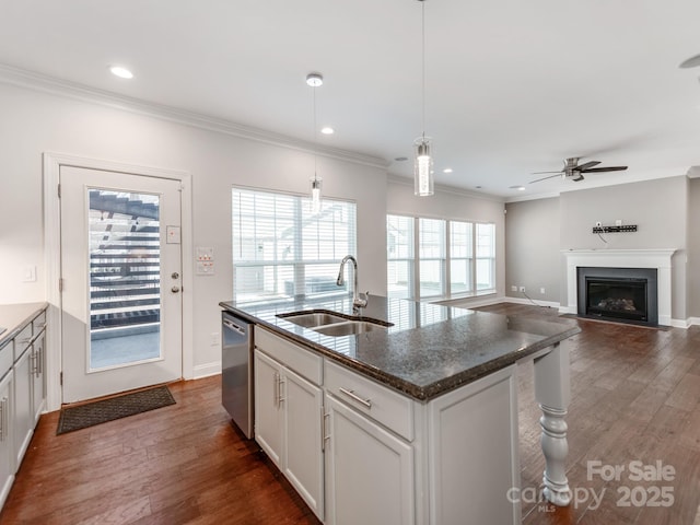 kitchen with dishwasher, dark wood-style floors, ornamental molding, a fireplace, and a sink