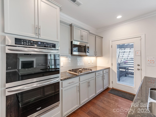 kitchen with dark wood-style flooring, visible vents, ornamental molding, appliances with stainless steel finishes, and gray cabinets