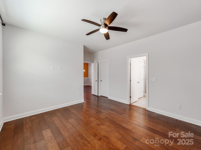 spare room featuring ceiling fan, wood-type flooring, and baseboards