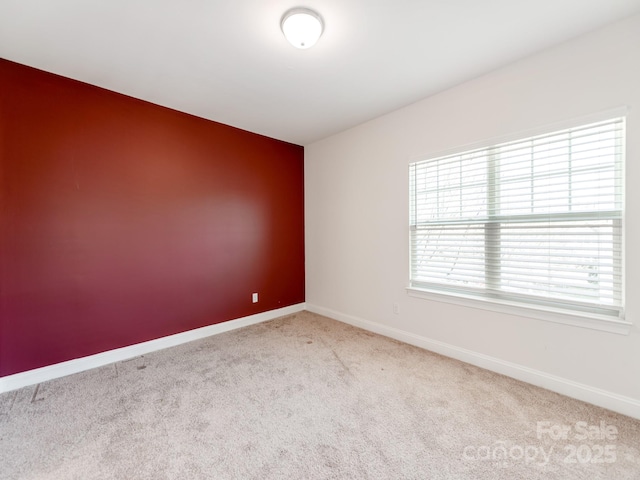 empty room with light carpet and baseboards