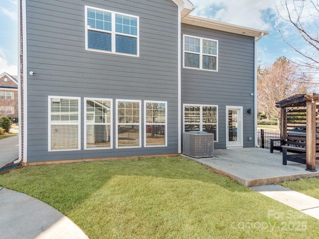 back of property with a patio area, a lawn, and central AC