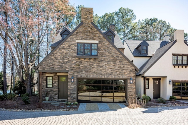 view of front facade featuring stone siding, stucco siding, and driveway